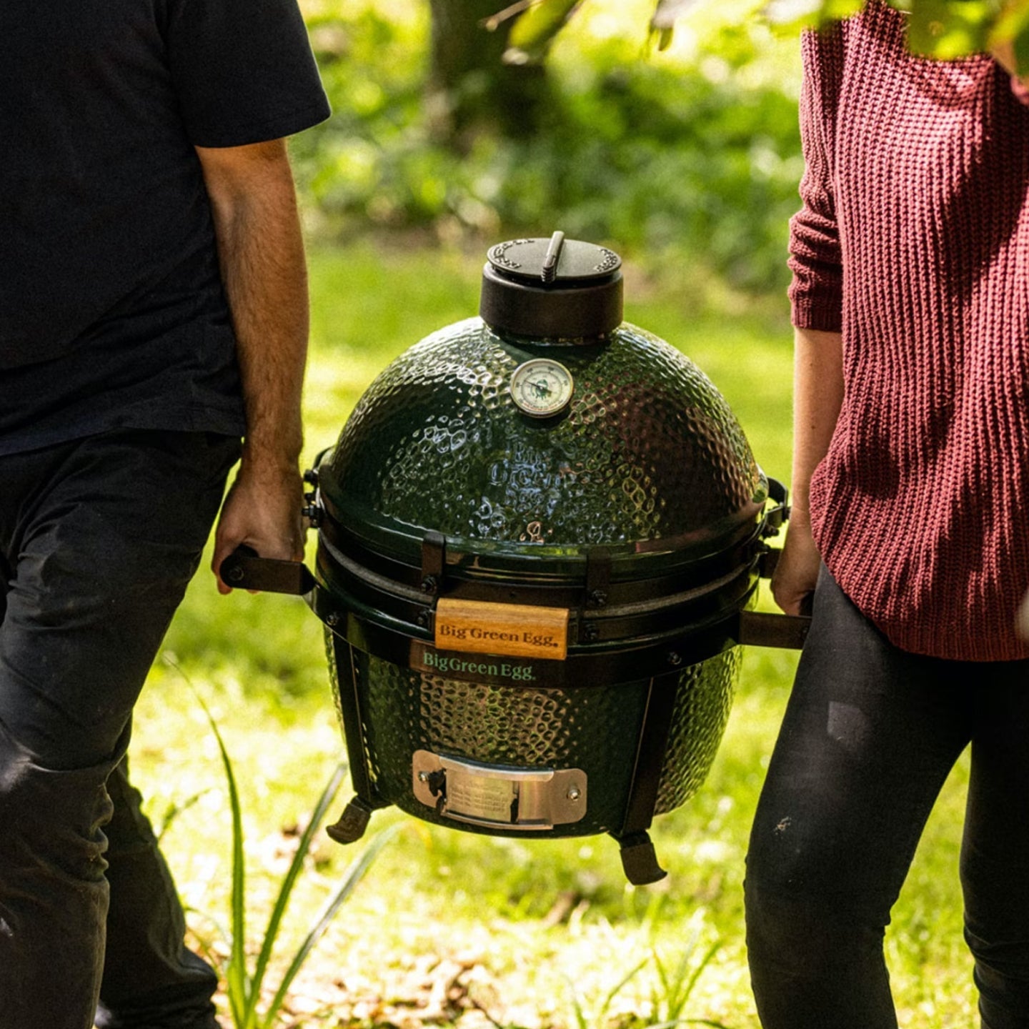 Big Green Egg Mini-Max Portable Ceramic Kamado Grill with Stand on a back patio or balcony